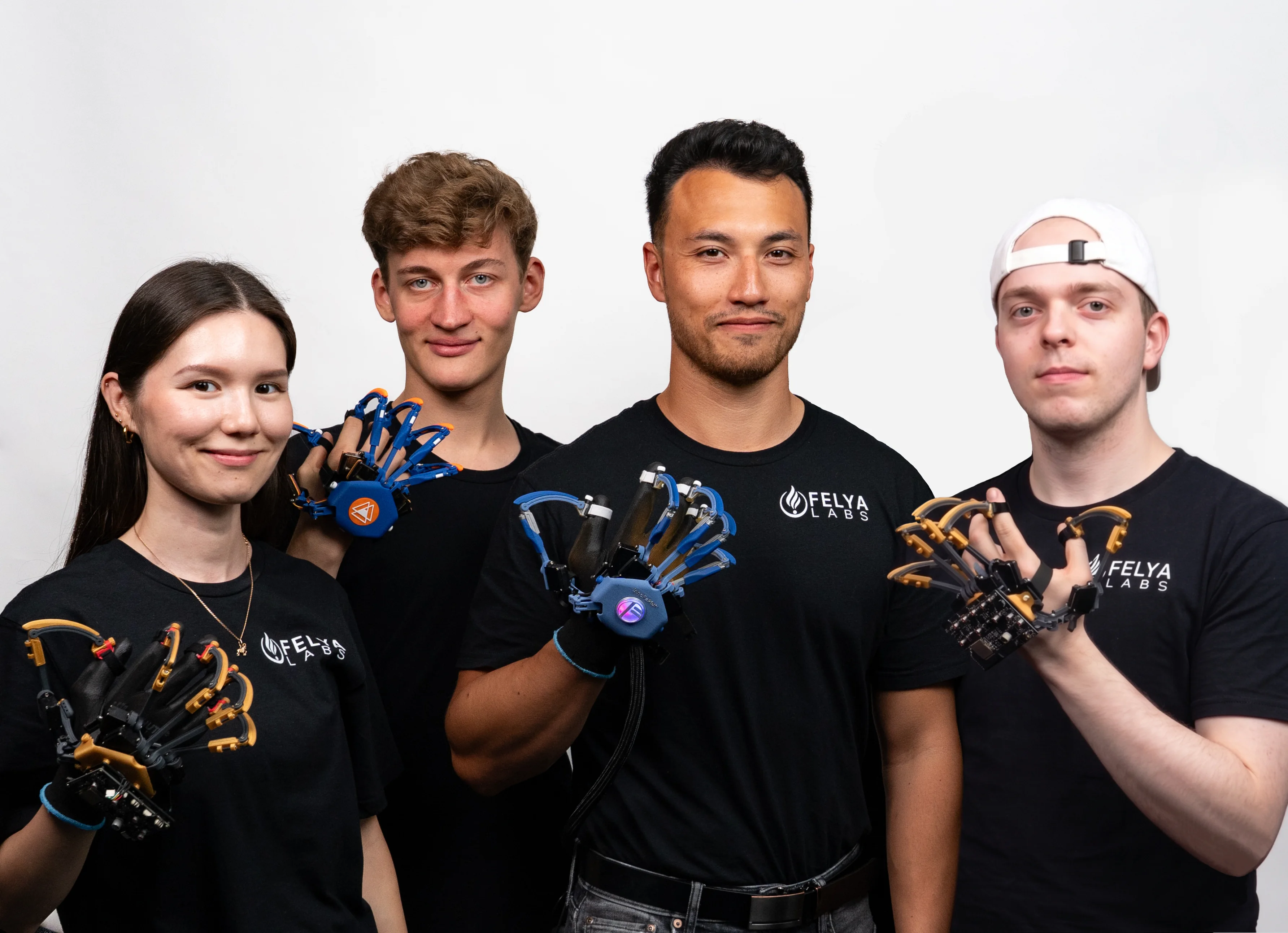 Four FELYA team members holding and wearing haptic glove prototypes.