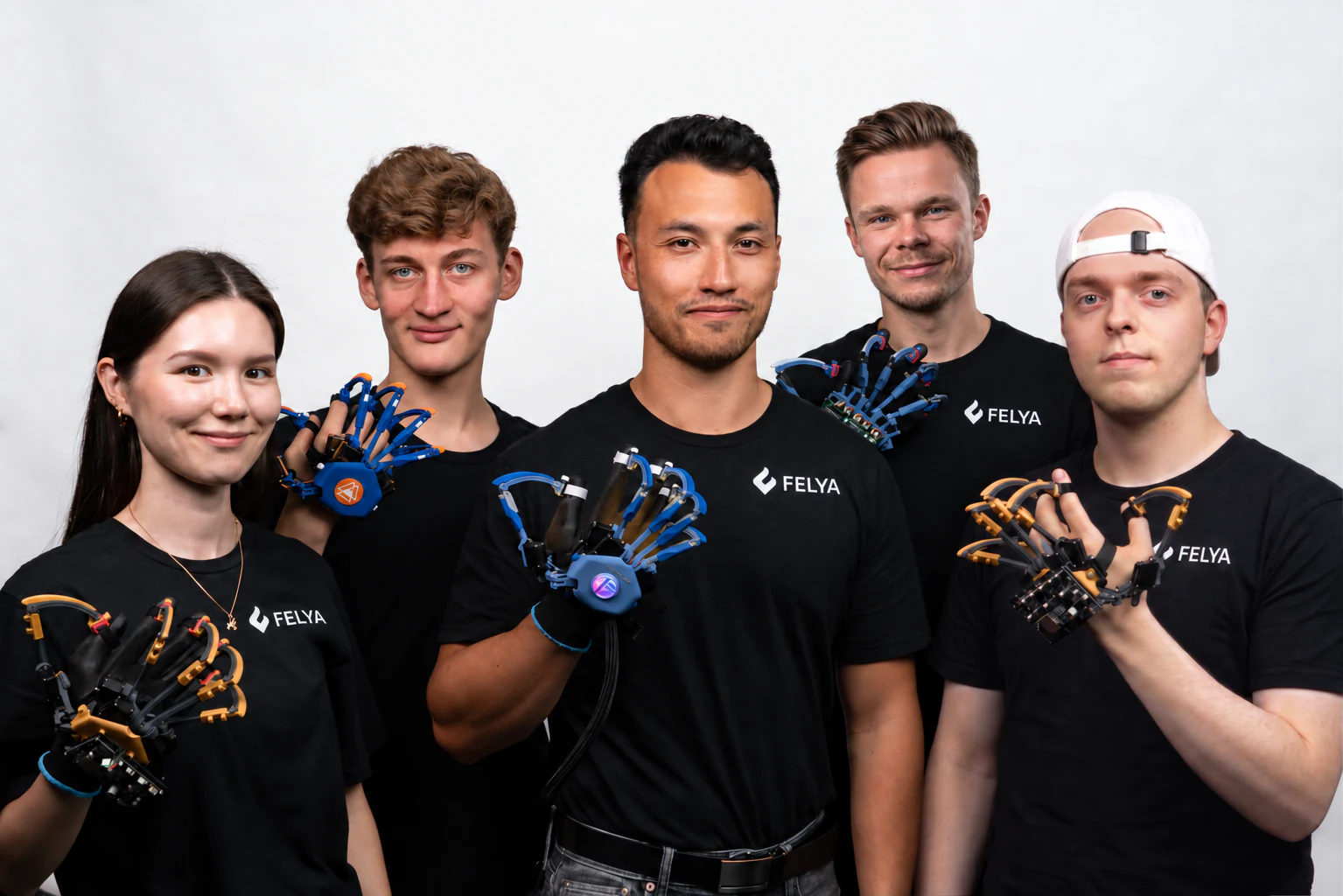 Five FELYA team members holding and wearing haptic glove prototypes.